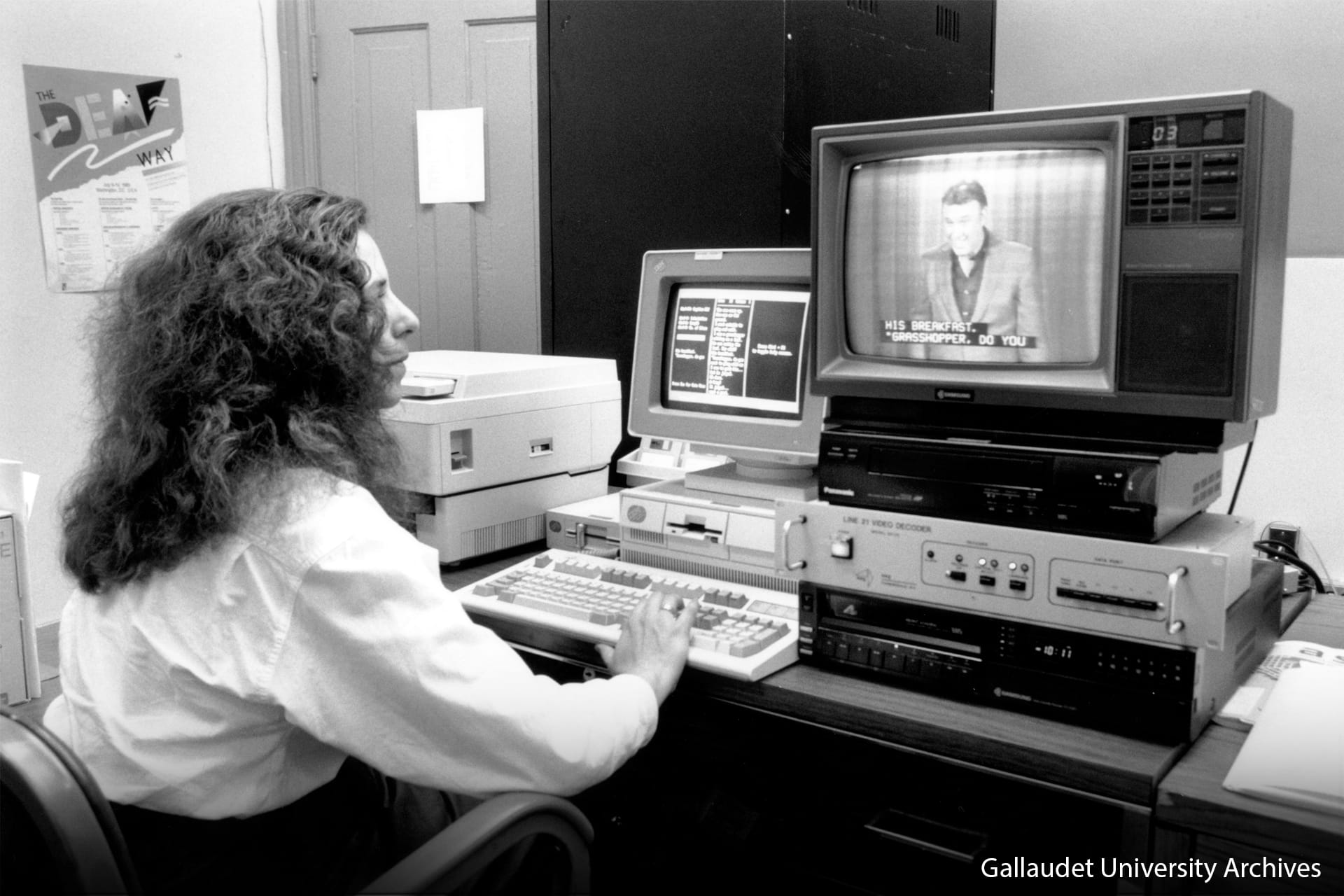 Black and white photo of an individual looking at an old monitor where there is a program with closed captions.