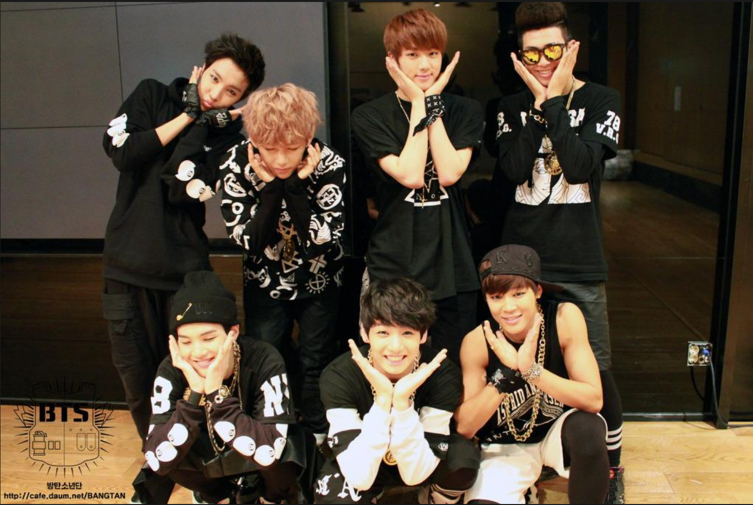 BTS in 2013 posing for the camera making flowers with their hands and faces